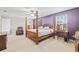 Main bedroom with four-poster bed, ensuite bathroom, and ample natural light from large windows at 12244 Fairlawn Dr, Riverview, FL 33579