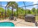 Relaxing screened-in pool with a fire pit, grill, and lush greenery for privacy at 12244 Fairlawn Dr, Riverview, FL 33579