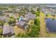 Aerial shot of a home with a screened-in pool and solar panels, set in a neighborhood by a pond at 12244 Fairlawn Dr, Riverview, FL 33579