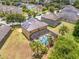 Aerial view of a home featuring a screened pool, solar panels, and lush landscaping in a residential neighborhood at 12244 Fairlawn Dr, Riverview, FL 33579