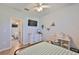 Well-lit bedroom features a ceiling fan, television, desk and easy access to the main bathroom at 12382 Shining Willow St, Riverview, FL 33579