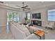The living room features a ceiling fan, a large sofa, and sliding glass doors to the outdoor patio at 12382 Shining Willow St, Riverview, FL 33579