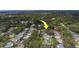 The aerial view showcases the property, complete with directional marker, amidst a backdrop of trees and homes at 1368 Whispering Pines Dr, Clearwater, FL 33764