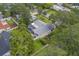 An aerial image showcases a screened pool area surrounded by the well-maintained yard and roof of the home at 1368 Whispering Pines Dr, Clearwater, FL 33764