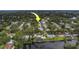 Waterfront property featuring a private dock and in-ground pool, set amongst lush landscaping at 1368 Whispering Pines Dr, Clearwater, FL 33764