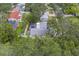 An aerial perspective shows a screened pool and yard, nestled amid the verdant setting of this property at 1368 Whispering Pines Dr, Clearwater, FL 33764
