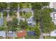 Home sits on a well-maintained lot with mature trees and features a screened-in pool area at 1368 Whispering Pines Dr, Clearwater, FL 33764
