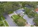 This aerial view showcases the property's landscaped yard, inground pool, and proximity to lush greenery at 1368 Whispering Pines Dr, Clearwater, FL 33764
