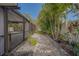 Serene backyard landscape with a pebble walkway, lush greenery, and tropical plants, perfect for relaxation and privacy at 1368 Whispering Pines Dr, Clearwater, FL 33764