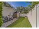 Fenced backyard showing a small shed, well maintained lawn, and hardscaped area with plumbing at 1368 Whispering Pines Dr, Clearwater, FL 33764