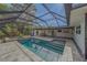 A backyard oasis featuring a screened-in pool, spa, and a lush, landscaped area for added privacy at 1368 Whispering Pines Dr, Clearwater, FL 33764
