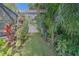 Backyard with lush tropical landscaping and a trellis, perfect for creating a peaceful and private outdoor space at 1368 Whispering Pines Dr, Clearwater, FL 33764