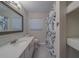 Bathroom featuring a vanity with a quartz countertop and a decorative shower curtain at 1368 Whispering Pines Dr, Clearwater, FL 33764
