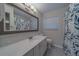 Bathroom features a vanity with a quartz countertop, and a decorative shower curtain at 1368 Whispering Pines Dr, Clearwater, FL 33764