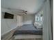 Bedroom with a ceiling fan, TV, and a view of a window with white curtains at 1368 Whispering Pines Dr, Clearwater, FL 33764