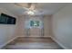Bedroom with a ceiling fan, hardwood floors, natural light, and a wall-mounted TV at 1368 Whispering Pines Dr, Clearwater, FL 33764