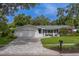 Home exterior showcasing a paved driveway, landscaped yard, and charming curb appeal at 1368 Whispering Pines Dr, Clearwater, FL 33764