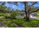 Well-maintained home exterior framed by mature trees and a lush green lawn, creating a serene setting at 1368 Whispering Pines Dr, Clearwater, FL 33764