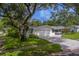 Lush landscaping frames the home's exterior, highlighting the inviting curb appeal and brick driveway at 1368 Whispering Pines Dr, Clearwater, FL 33764