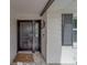 Close-up of the front door with a Welcome mat, surrounded by white brick and modern design elements at 1368 Whispering Pines Dr, Clearwater, FL 33764