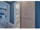 Hallway view of bathroom with blue accent wall and a sliding barn door at 1368 Whispering Pines Dr, Clearwater, FL 33764