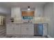Charming kitchen area with white cabinets, stainless dishwasher and a decorative herringbone backsplash design at 1368 Whispering Pines Dr, Clearwater, FL 33764