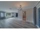 Bright living room featuring gray wood floors, modern lighting, and large windows allowing for natural light at 1368 Whispering Pines Dr, Clearwater, FL 33764