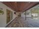 Beautiful covered patio with dark-stained wood ceiling, modern tiling, and access to the pool area at 1368 Whispering Pines Dr, Clearwater, FL 33764