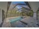 Tranquil backyard with a screened-in pool, spa, and a beautifully designed patio area for ultimate relaxation at 1368 Whispering Pines Dr, Clearwater, FL 33764
