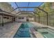 Backyard oasis featuring a screened-in pool, spa, and patio area, ideal for relaxing and entertaining guests at 1368 Whispering Pines Dr, Clearwater, FL 33764