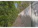 Side yard features a pea gravel path between a white fence and a tall hedge at 1368 Whispering Pines Dr, Clearwater, FL 33764