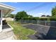 Expansive backyard featuring a shed, white fence, and a large area covered with black squares at 13898 Jamaica Dr, Seminole, FL 33776