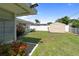 Backyard includes a shed, flower bed with vibrant red blooms, and a well-kept lawn at 13898 Jamaica Dr, Seminole, FL 33776