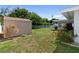 View of the backyard showcasing a shed, fenced perimeter, and green lawn at 13898 Jamaica Dr, Seminole, FL 33776