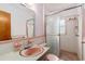Charming bathroom featuring a pink sink, matching toilet, and a shower with sliding glass doors at 13898 Jamaica Dr, Seminole, FL 33776