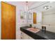 Bathroom with a vintage tile countertop, large mirror, and decorative hanging light at 13898 Jamaica Dr, Seminole, FL 33776