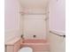 Retro bathroom with tiled walls, bathtub, toilet, and chrome towel rack at 13898 Jamaica Dr, Seminole, FL 33776