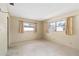 This bedroom offers neutral walls, speckled floor, and two sunny windows at 13898 Jamaica Dr, Seminole, FL 33776