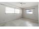 A bedroom featuring speckled floor, neutral walls, and two bright windows at 13898 Jamaica Dr, Seminole, FL 33776