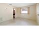 A bedroom with speckled floor, neutral walls, and window to let in natural light at 13898 Jamaica Dr, Seminole, FL 33776