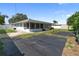 Rear view of the home featuring a screened in porch, shed, and expansive yard at 13898 Jamaica Dr, Seminole, FL 33776