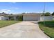 Exterior of single-story home features a long driveway leading to the attached two-car garage at 13898 Jamaica Dr, Seminole, FL 33776