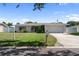 Exterior view of the property showcasing the tidy lawn, neutral paint, and manicured landscaping at 13898 Jamaica Dr, Seminole, FL 33776