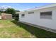 Side view shows the house with a backyard shed, privacy fence, and lush green lawn at 13898 Jamaica Dr, Seminole, FL 33776