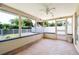Enclosed Florida room features tile floor, ceiling fan, and large windows with backyard views at 13898 Jamaica Dr, Seminole, FL 33776