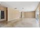 Open living room with neutral walls, terrazzo floors, and screened-in lanai access at 13898 Jamaica Dr, Seminole, FL 33776