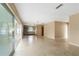 Open floor plan with living room, kitchen, and lanai access, all featuring terrazzo floors at 13898 Jamaica Dr, Seminole, FL 33776