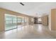 Spacious living room featuring terrazzo flooring, screened-in lanai access, and neutral paint at 13898 Jamaica Dr, Seminole, FL 33776
