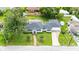 Aerial view of a well-maintained home with a blue roof, lush backyard, pool and a brick walkway at 13917 8Th St, Dade City, FL 33525