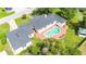 Aerial view of the house featuring a kidney-shaped pool, brick patio, and lush greenery at 13917 8Th St, Dade City, FL 33525